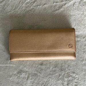 Gucci trifold leather wallet in gold.